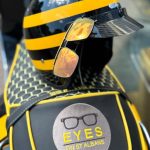 Sunglasses from EYES on St Albans sitting on the back of Jez's vespa bike - all branded in black, yellow and EYES on St Albans logos