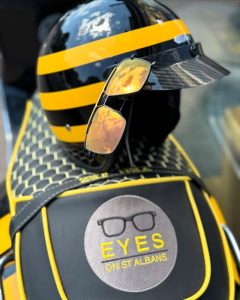 Sunglasses from EYES on St Albans sitting on the back of Jez's vespa bike - all branded in black, yellow and EYES on St Albans logos